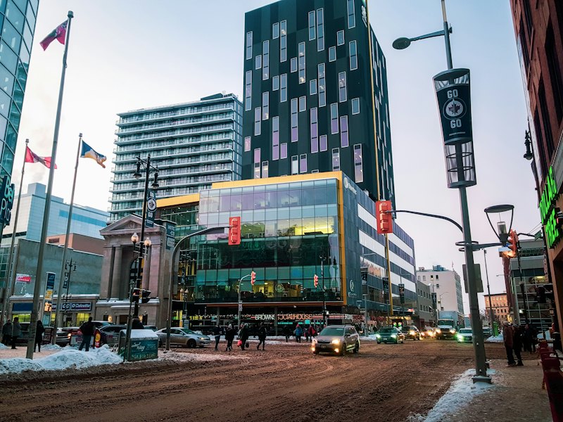 Winter street in downtown Winnipeg with light traffic and snow on the boulevards