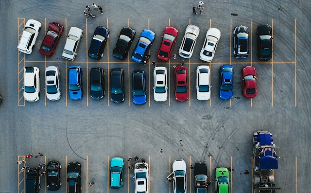 Aerial view of a large parking lot with rows of parked cars