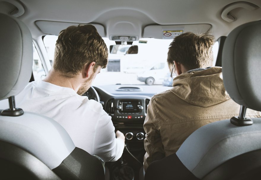 Instructor in the passenger seat beside a learner before a practice drive